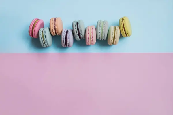 Makaron- oder Makronenkekse auf pastellblauem und rosa Hintergrund. Kopierraum. — Stockfoto