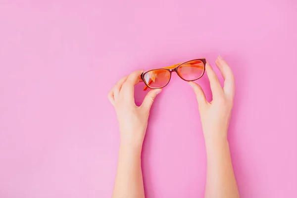 Hände mit Brille auf rosa Hintergrund. — Stockfoto