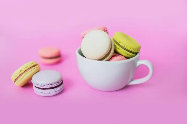 Galletas macaroon o macaron en taza sobre fondo rosa . —  Fotos de Stock