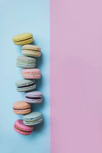 Galletas macaroon o macaroon sobre fondo rosa pastel y azul. Copiar espacio . —  Fotos de Stock