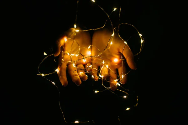 Luci di Natale con caldo splendente nelle mani femminili . — Foto Stock