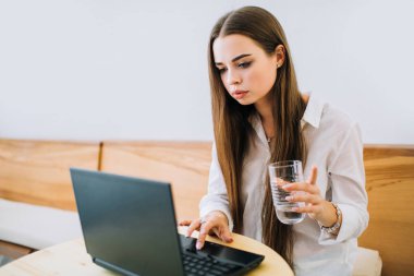 Dizüstü bilgisayarda çalışan genç konsantre kız.