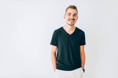 İzole edilmiş beyaz arka planda duran mutlu genç adam..