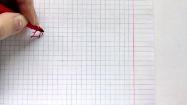 Beyaz Avrupalı kadın solak sol eliyle bir not defterine kırmızı kalemle 1 Eylül ifadesini yazıyor. Kare kağıt üzerinde Eylül ayının ilk kaleminde el yazısı yazıt