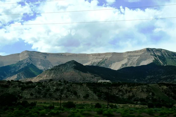 Textured landscape. Light beautifully falls on the green and gray mountains through the clouds of the sky. Colorado State. rocky mountains. Not far from Colorado river. Beautiful views of the spring green mountains. USA. May.