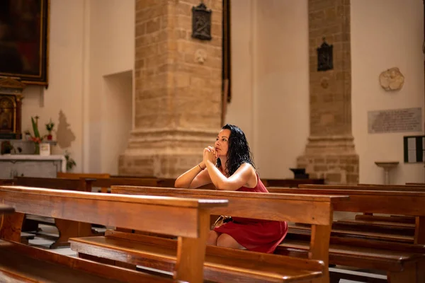 An alone woman prays in the church. Praying concept in the church.