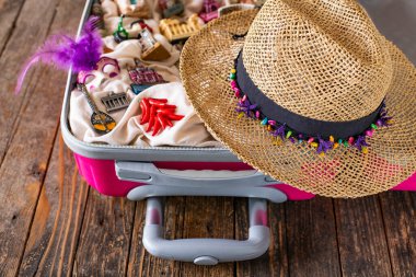 İçinde turistik yerler ve hatıralar olan pembe bir bavul.