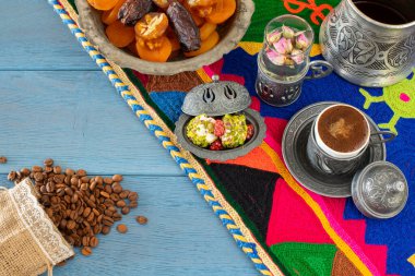 Otantik fincanda kahve ve kuru meyveli el yapımı halıda su.