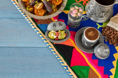 Otantik fincanda kahve ve kuru meyveli el yapımı halıda su.