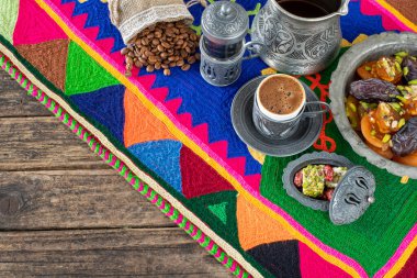 Otantik fincanda kahve ve kuru meyveli el yapımı halıda su.