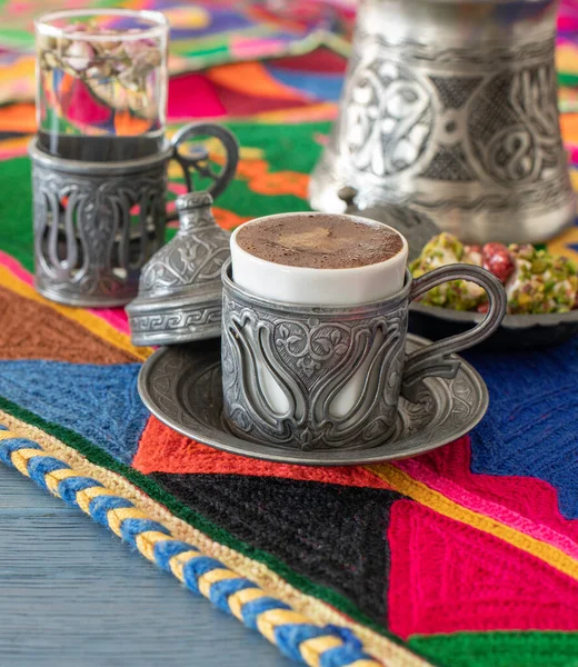 Otantik fincanda kahve ve kuru meyveli el yapımı halıda su.