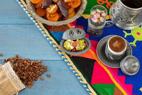 Otantik fincanda kahve ve kuru meyveli el yapımı halıda su.