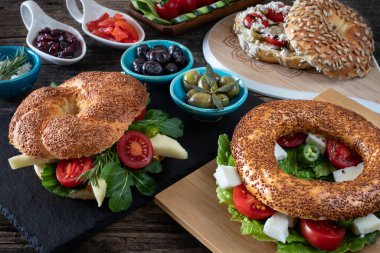 Kahvaltı için doldurulmuş taze bir simit burger. Birçok iştah açıcı ile simit konsept. 