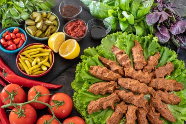 Cig kofte (Türkçe çiğ köfte) marul, domates, turşu ve limon ile birlikte, sıcak chee kofta. Türk yerel çiğ gıda purosu 