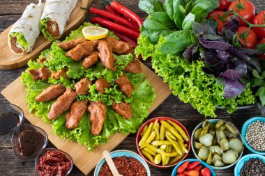 Cig kofte (Türkçe çiğ köfte) marul, domates, turşu ve limon ile birlikte, sıcak chee kofta. Türk yerel çiğ gıda purosu 