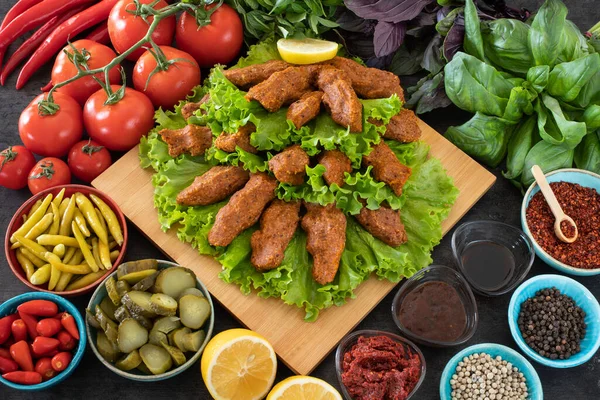 Cig kofte (Türkçe çiğ köfte) marul, domates, turşu ve limon ile birlikte, sıcak chee kofta. Türk yerel çiğ gıda purosu 