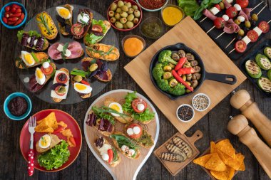 Köy ahşap masada siyah arka planda bir sürü tapas var. Üst Düzey Akdeniz Gıda Konsepti.