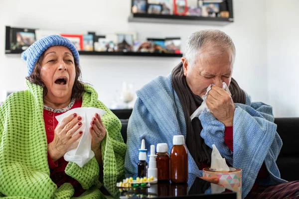 Sick senior couple under the blanket with pills , covid 19, flu and cold concept with medicines