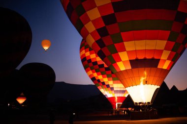 Kapadokya, Türkiye 'de güneş doğarken uçan sıcak hava balonları. Sıcak hava balonları ile ekstrem macera konsepti  