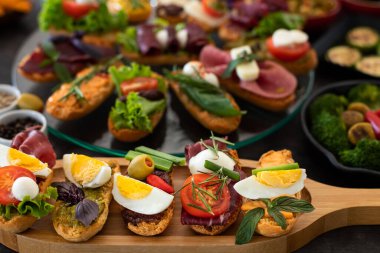 Köy ahşap masada siyah arka planda bir sürü tapas var. Üst Düzey Akdeniz Gıda Konsepti.