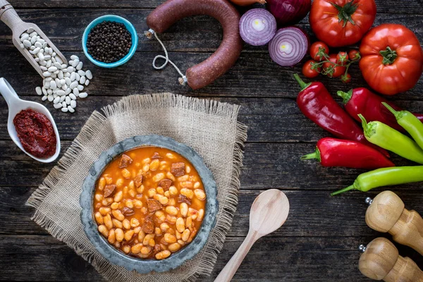 Türk yemeği Kuru fasulye pilavı (deniz fasulyesi ve pirinç) masada sucuk (Türk sosisi). Üst görüşlü yerel geleneksel yiyecekler konsepti. 