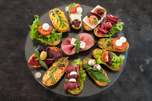 Kırsal ahşap masada kırmızı şarapla bir sürü tapas. Üst Düzey Akdeniz Gıda Konsepti.