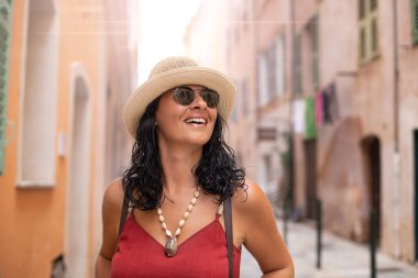 Korsika 'nın dar sokaklarında bir turist kadın yürüyor. Avrupa 'da aileyle seyahat kavramı.