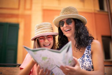 Bir turist kadın ve kızı haritaya bakıyor.