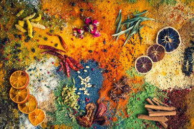 Masada çok renkli baharatlar ve kurutulmuş meyveler var. Baharatlı arka plan kavramı.