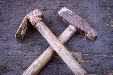 Tahta duvarın önünde kullanılmış kürek ve kazma. Çiftçi aletleri kavramı. 