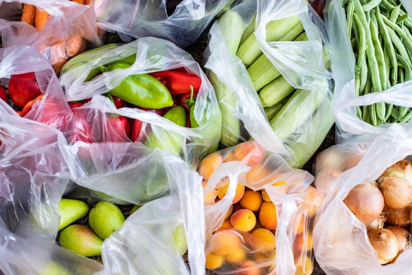 Bir sürü sebze ve meyve içeren yerel pazardan bir sürü plastik torba. Naylon poşetlerle çevre kirliliği