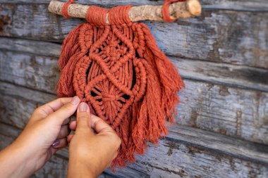 Evde makrome dokumak. Makrome yapan bir kadının eli.. 