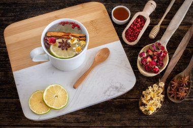 Masanın üzerinde çok renkli kurutulmuş çay yaprakları ve çiçekler var. Üst görüşlü bitkisel çay kavramı. 