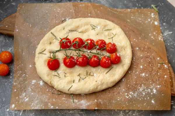 Bread, focaccia with cherry tomatoes and rosemary. Tasty and beautiful food. Italian Cuisine.