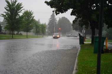 Fond du Lac, Wisconsin / ABD - 10 Temmuz 2020: Fond du Lac sakinleri, 2020 yılının Temmuz ayında öğleden sonra şiddetli yağmur yağışından taşan araçlarıyla sel basmış caddelerden geçtiler..