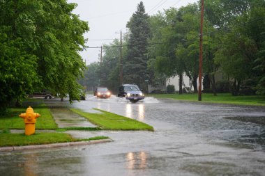 Fond du Lac, Wisconsin / ABD - 10 Temmuz 2020: Fond du Lac sakinleri, 2020 yılının Temmuz ayında öğleden sonra şiddetli yağmur yağışından taşan araçlarıyla sel basmış caddelerden geçtiler..