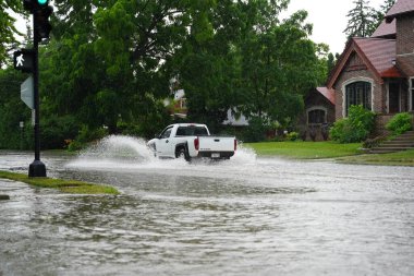 Fond du Lac, Wisconsin / ABD - 10 Temmuz 2020: Fond du Lac sakinleri, 2020 yılının Temmuz ayında öğleden sonra şiddetli yağmur yağışından taşan araçlarıyla sel basmış caddelerden geçtiler..