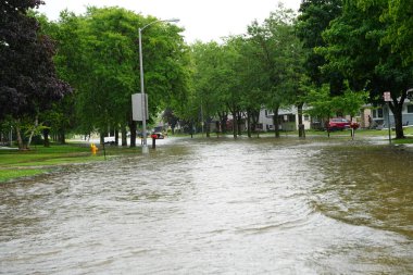 Fond du Lac sakinleri, 2020 yılının Temmuz ayında öğleden sonra sağanak yağmurdan taşan araçlarıyla sel basmış caddelerde ilerliyorlar..  