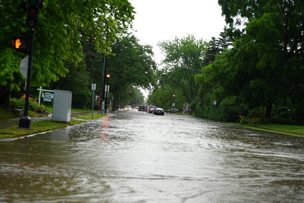 Fond du Lac, Wisconsin / USA - July 10th, 2020: Citizens of Fond du Lac drive through the flooded streets in their vehicles from the huge downpour of rain during the afternoon in july 2020.