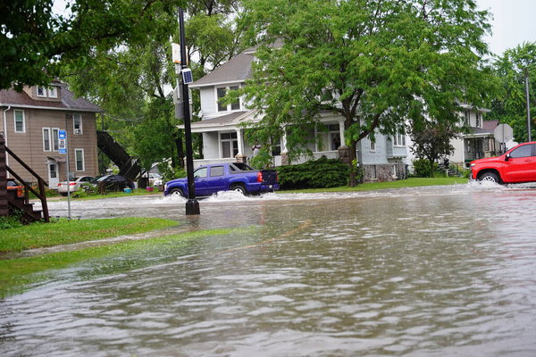 Fond du Lac, Wisconsin / USA - July 10th, 2020: Citizens of Fond du Lac drive through the flooded streets in their vehicles from the huge downpour of rain during the afternoon in july 2020.