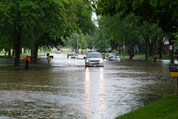 Citizens of Fond du Lac drive through the flooded streets in their vehicles from the huge downpour of rain during the afternoon in july 2020.  