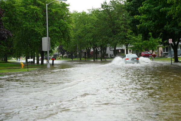 Citizens of Fond du Lac drive through the flooded streets in their vehicles from the huge downpour of rain during the afternoon in july 2020.  