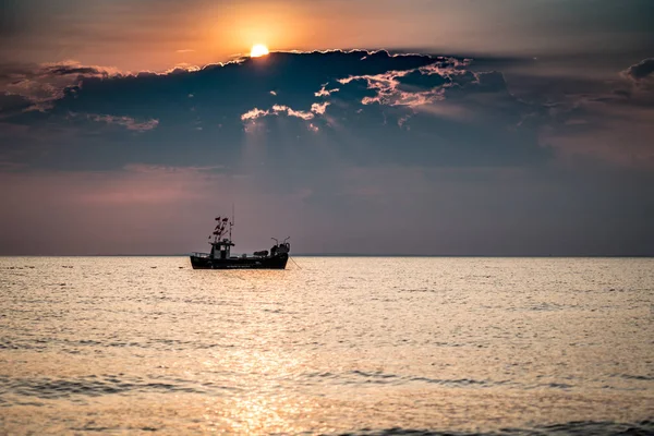 Ein Boot auf dem Meer bei Sonnenaufgang — Stockfoto