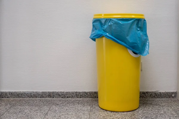 a yellow barrel with a lid stands in the hallway