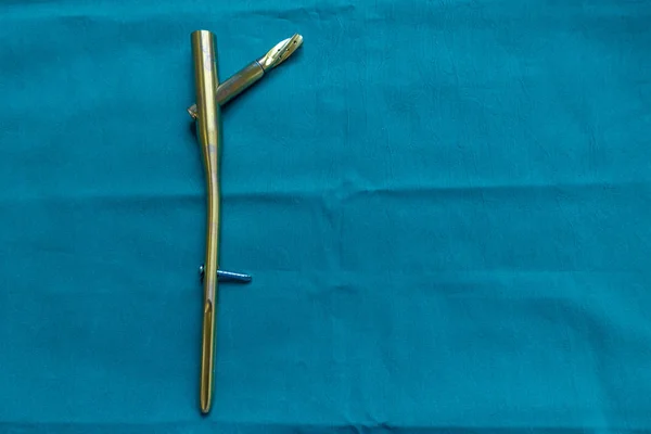 Een explanted Titanium femur spijker op een groene chirurgische draperen — Stockfoto