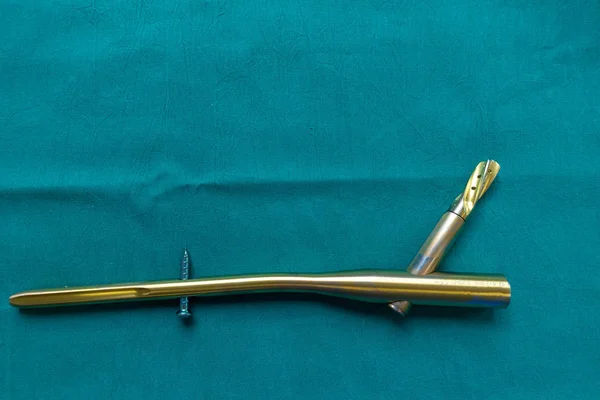 Un clavo de fémur de titanio explorado en una cortina quirúrgica verde — Foto de Stock
