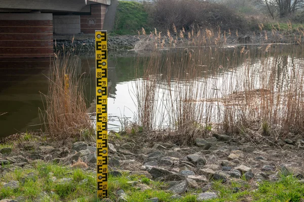 bir nehrin yanında bir seviye göstergesi