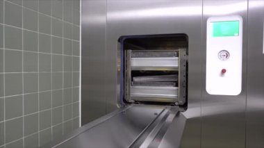 bir sterilizatör açar ve aletleri serbest bırakır