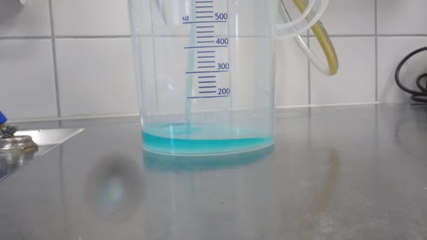 青い化学クリーナーの360ミリリットルは測定カップに注がれています — ストック動画