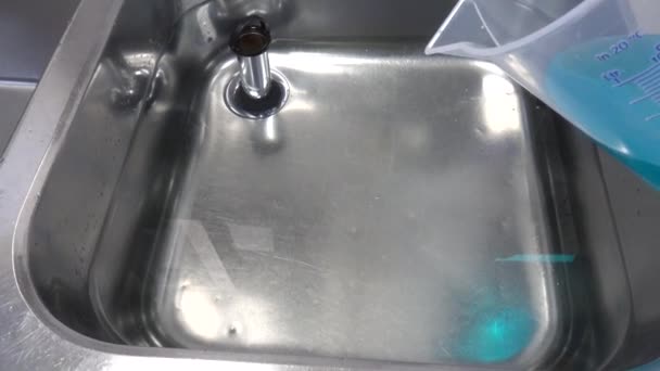 Eine Blaue Flüssigkeit Wird Ein Becken Mit Wasser Gekippt — Stockvideo